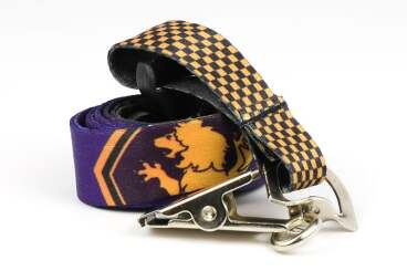 Rolled lanyard with checkered pattern and lion print, featuring a metallic clip.