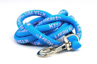 Blue lanyard with white text and metal clip coiled on a surface.