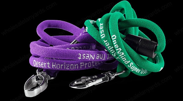 Purple and green lanyards with white text and carabiner attachments