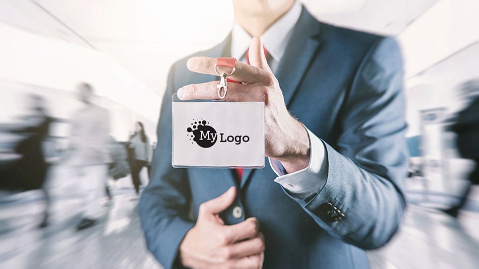 Business professional holding up lanyard with a badge displaying a corporate logo