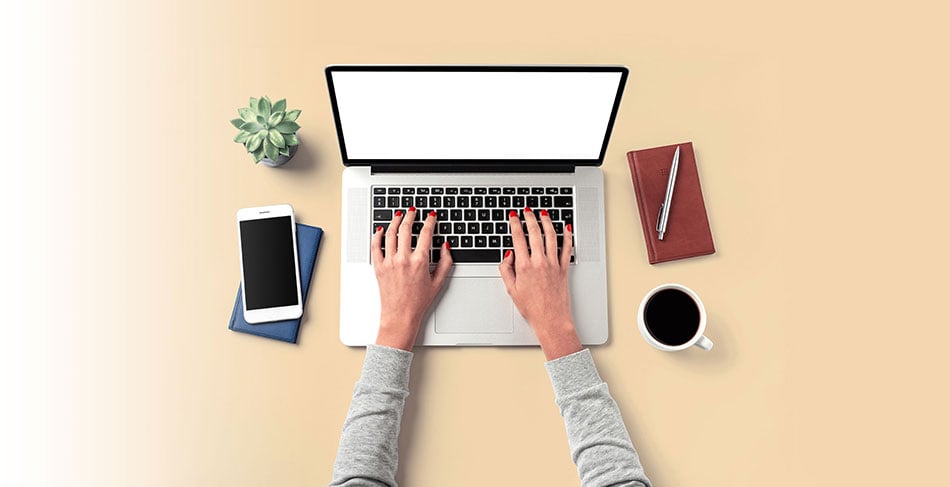 Hands typing on a laptop